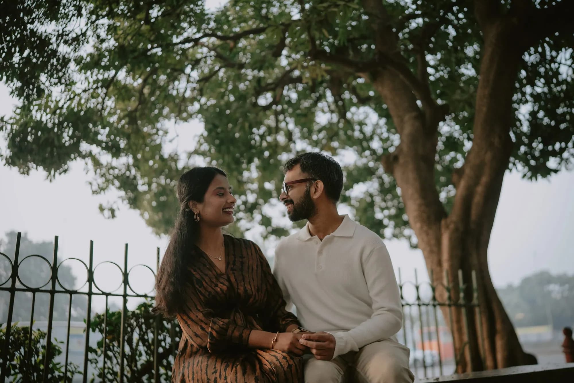 Couple sitting together under a tree, laughing