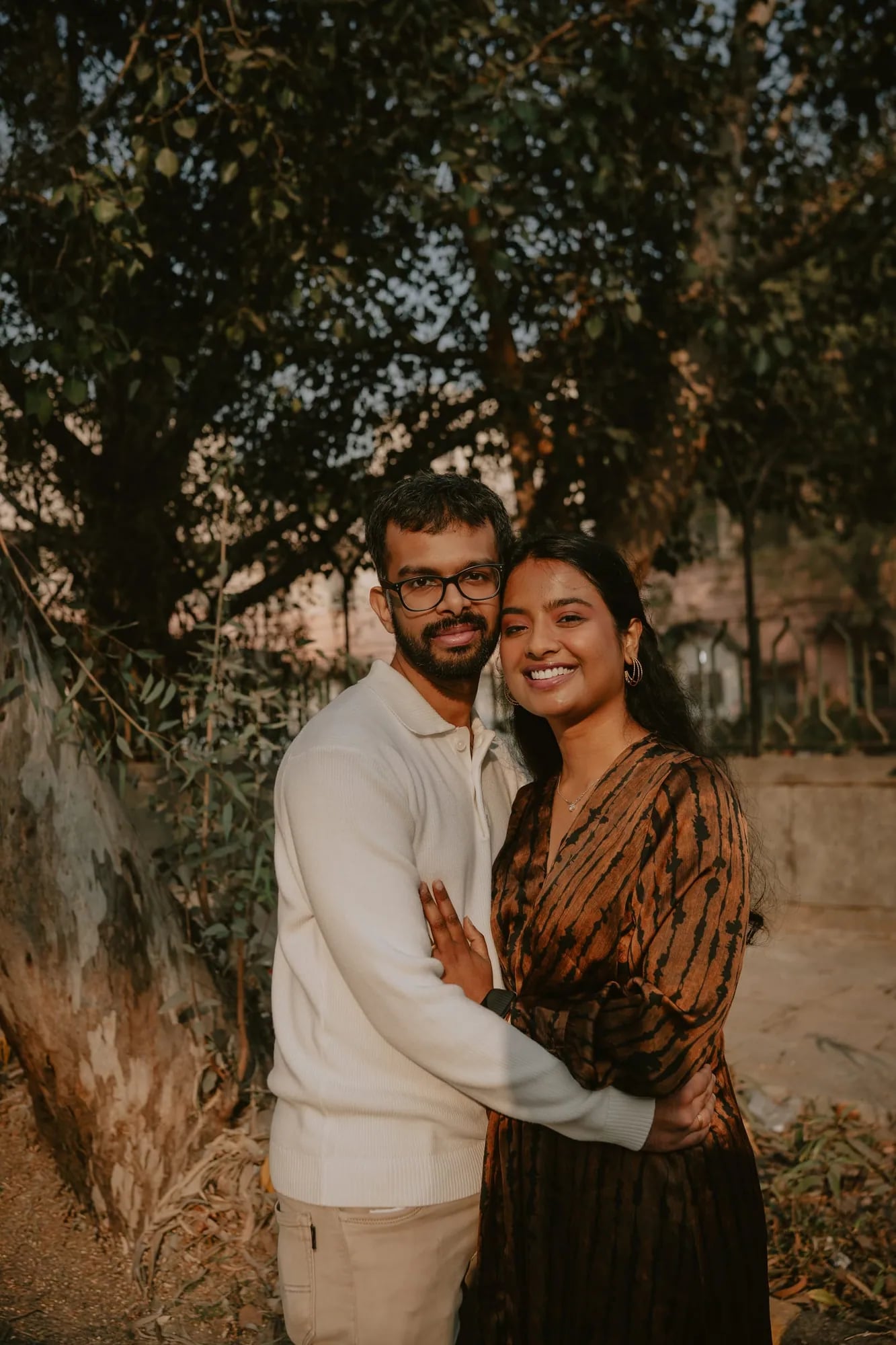 Couple holding each other close outdoors, portrait frame